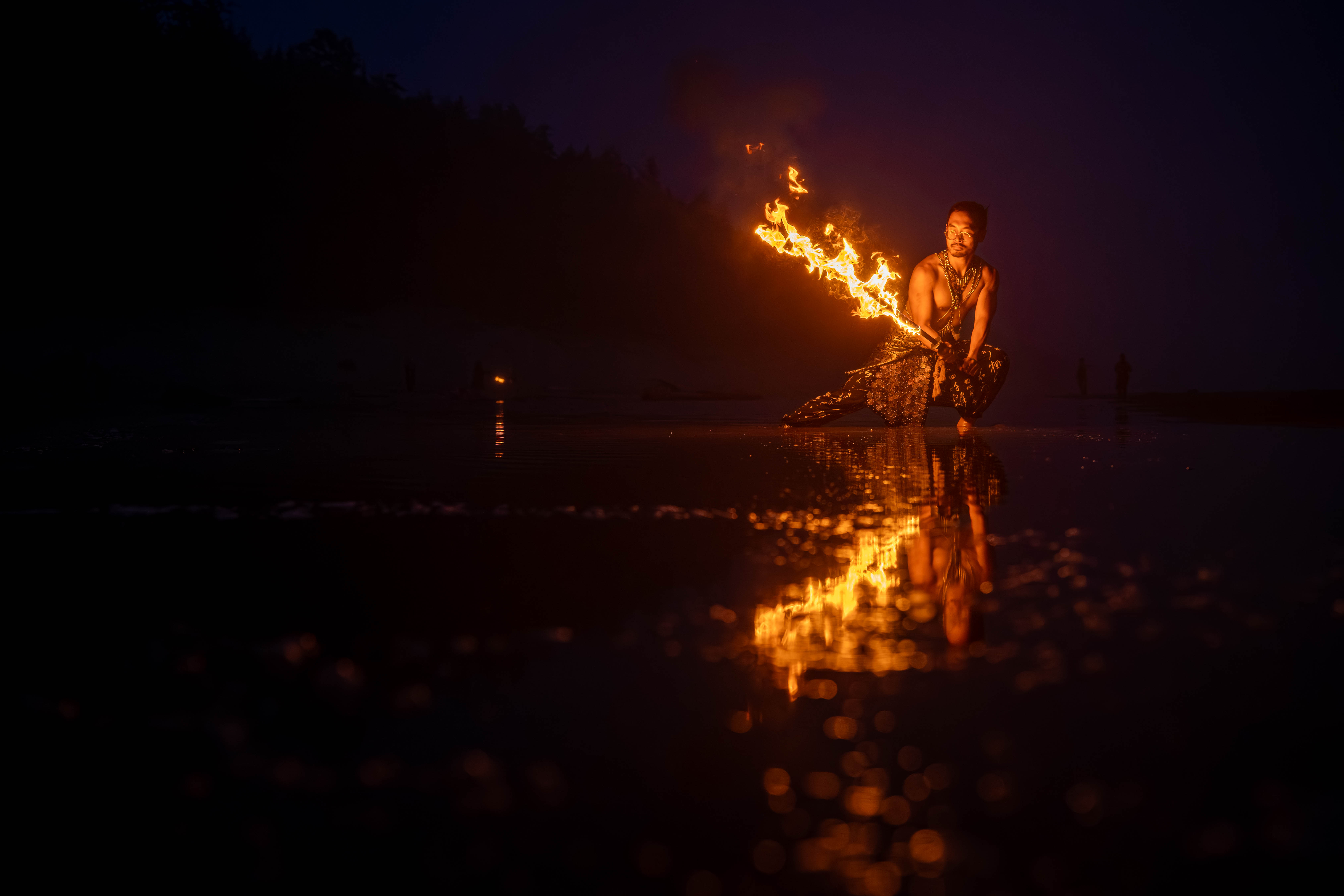 Fire photography — flames reflected on water at night